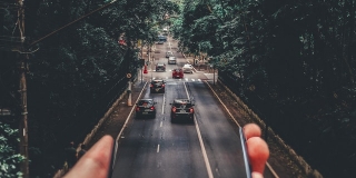 Smartphone dont l'écran sur prolonge en route avec des voitures dessus