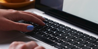 Image d'un ordinateur portable et d'une main sur le clavier